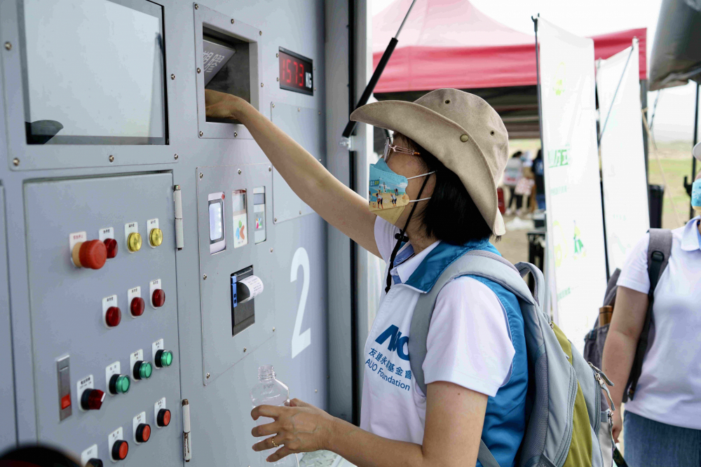 志工們將拾起的寶特瓶投入「好歸塑專車」，讓廢棄塑料空瓶可以直接粉碎、縮小體積，未來將可再製成購物袋、寶特衣、悠遊卡等生活用品